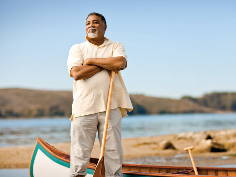 An image of a proud man standing in a canoe