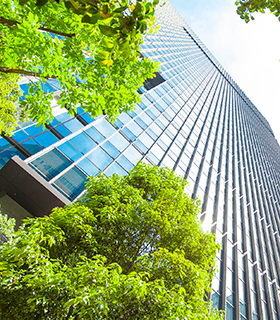 Image of office building with green trees in front.