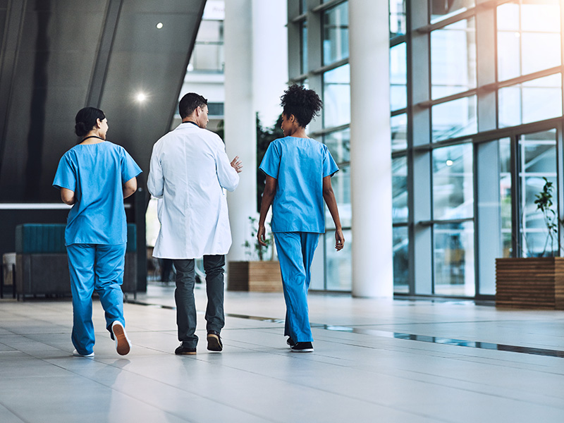 Doctors walk down a hospital corridor.